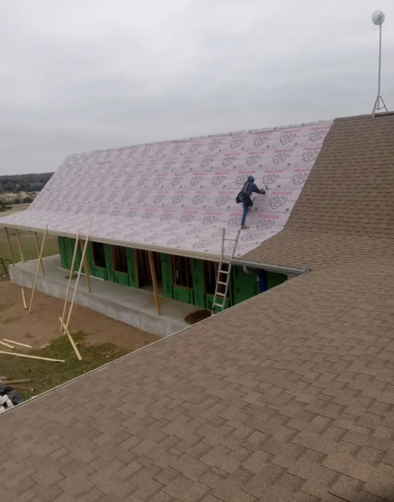 Worker preparing underlayment for a metal roof installation in North Charleston